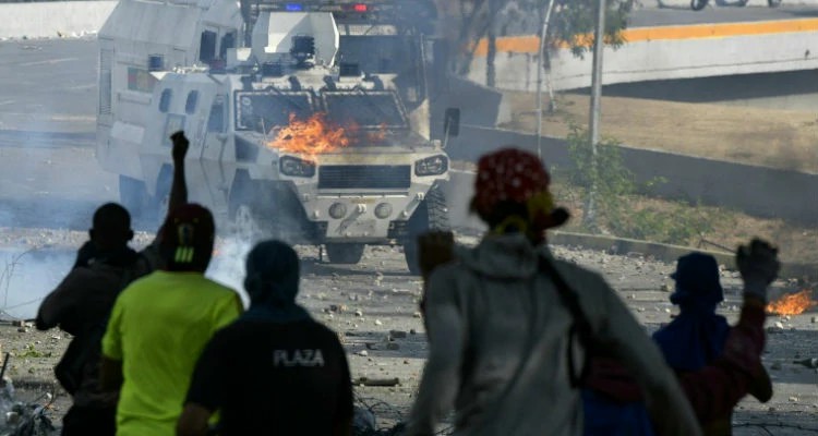 Manifestantes protestam nas ruas contra Maduro e enfrentam as forças de segurança em Caracas (Imagem: AFP)
