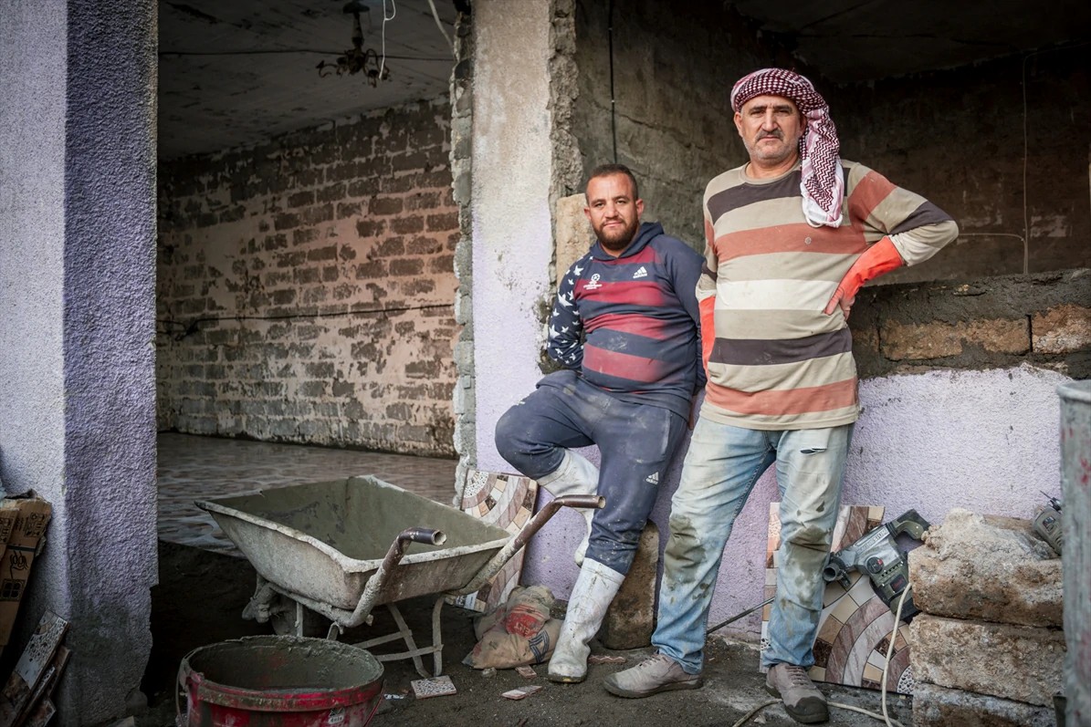 Famílias trabalham na reconstrução de Qaraqosh, após encontrarem a cidade devastada pelo EI