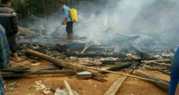 Bombeiro trabalha para extinguir o fogo na casa de Quang, incendiada por moradores por ele ser cristão