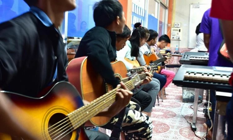 Ouk é um dos alunos de violão que vivenciou as consequências da perseguição aos cristãos no Laos